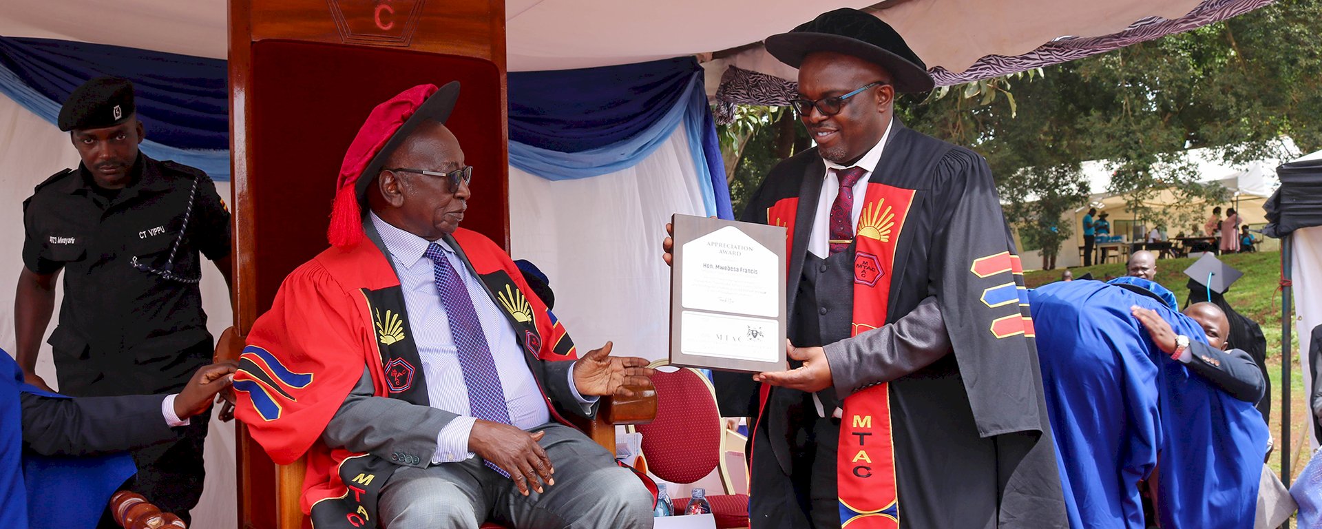 The ED hands over the awards  to Hon. Minister